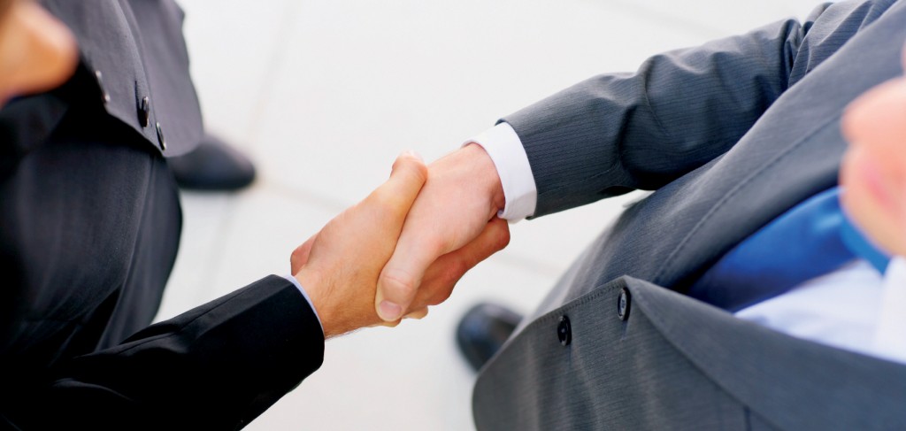 Businesspeople shaking hands, finishing up a meeting.